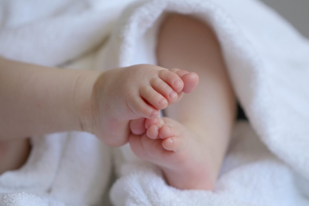 Pies descalzos de un bebé sobre una toalla blanca en casa