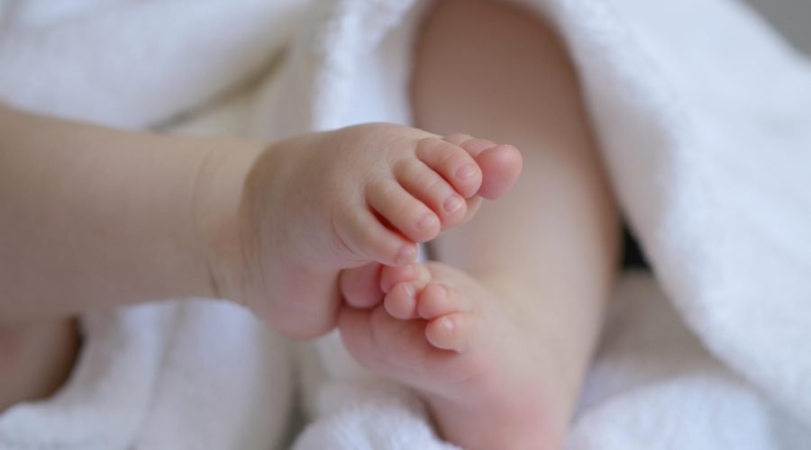 Pies descalzos de un bebé sobre una toalla blanca en casa